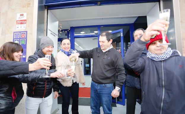 Javier Marcos sirve champán a las puertas de la administración para celebrar la venta del segundo premio./MANUEL LAYA