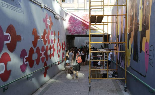 Los vecinos observan el trabajo de los artistas urbanos en el túnel.