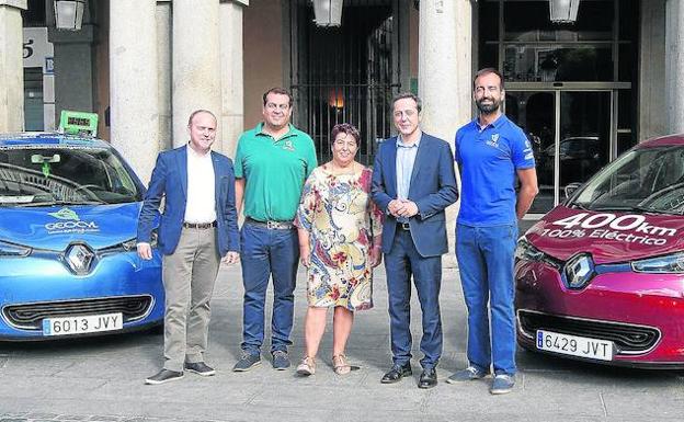 Javier Martín (i), de Emaysa Renault, con Clara Luquero, José Bayón y los socios de Geocyl, Eduardo Bustillo y Pablo Rodríguez, junto a los coches eléctricos Renault Zoe en la fachada del Ayuntamiento.