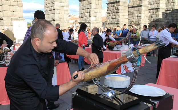 Uno de los especialistas corta el jamón en la plaza del Azoguejo.