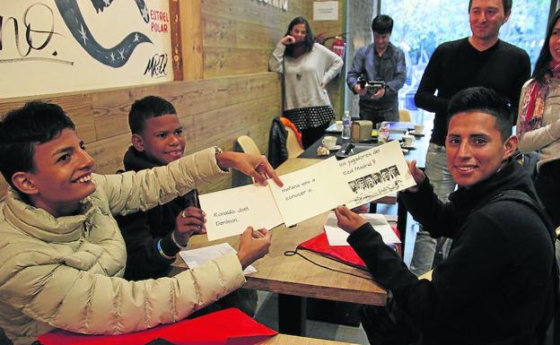 Los tres chicos muestran las tarjetas en las que se les anuncia la sorpresa. /J. NIETO