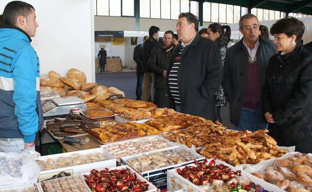 El alcalde de Fuentepelayo, Daniel López Torrego, conversa con uno de los vendedores tras la apertura oficial de la Feria de Alimentación en una edición anterior. /M. Rico