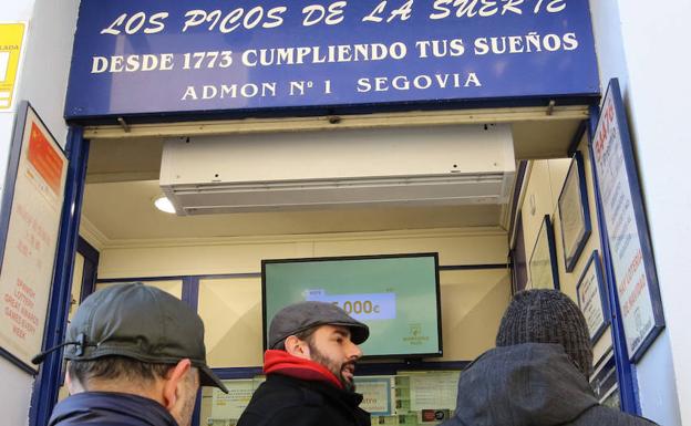 Varios clientes esperan para comprar sus décimos en la oficina más antigua de Segovia, en el número 56 de la calle Juan Bravo. /Antonio De Torre