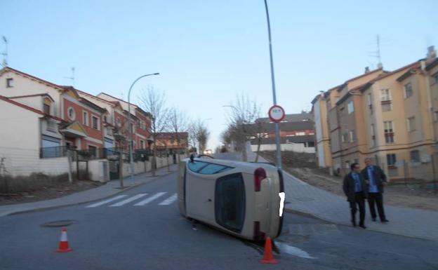 El coche, volcado en la confluencia entre la Plaza de Valdihuertos y la calle Botiller. /M. Rico