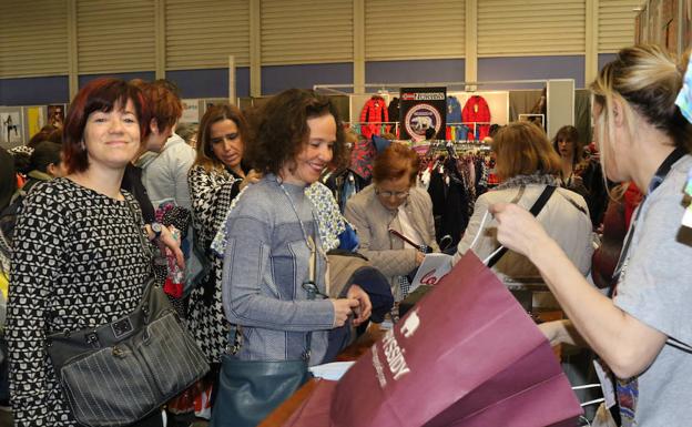 Varias compradoras son atendidas en uno de los 50 expositores tras la inauguración esta mañana./Henar Sastre