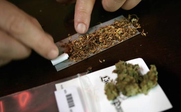Un joven lía un porro de marihuana./REUTERS