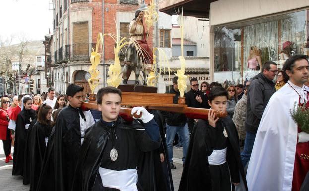 Cuatro niños cofrades portan la imagen de La Borriquilla, ayer en Cuéllar. /M. R.