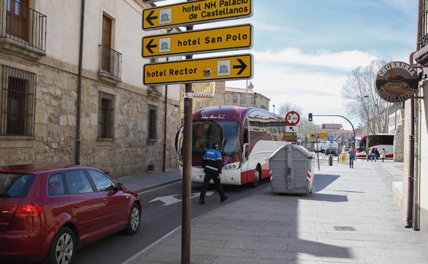 Un policía local ayuda a maniobrar a uno de los autobuses, que se había metido por dirección contraria por San Pablo./Manuel Laya