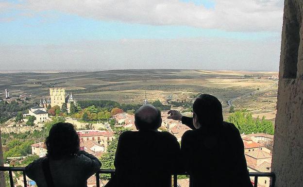 Tres personas contemplan la ciudad desde la torre. /Tanarro