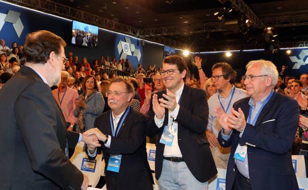El presidente del PP de Castilla y León, Alfonso Fernández Mañueco (centro), saluda a Mariano Rajoy antes de intervenir en la mesa Diálogos Populares en la Convención Nacional./ICAL