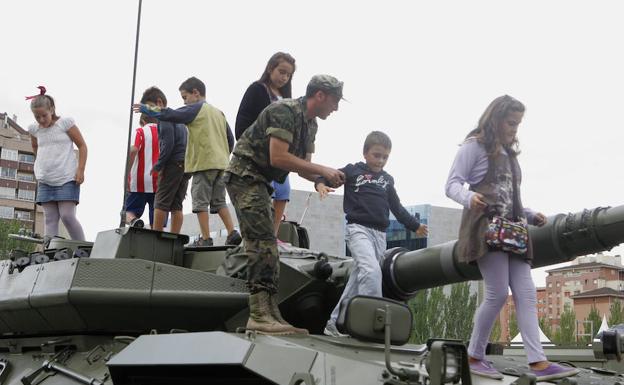 Los soldados enseñan a los niños los objetos de la exposición del ejército en la Feria de Muestras de Valladolid./Henar Sastre