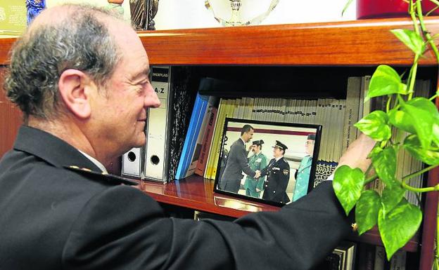 El responsable policial en Segovia revisa unos libros en una estantería./ A. de Torre