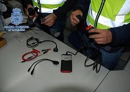 Dos agentes inspeccionan los dispositivos incautados. / Policía Nacional/