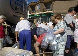Vecinos de Castronuevo, en Zamora, se abastecen de agua para el consumo y para cocinar. :: GABRIEL VILLAMIL/
