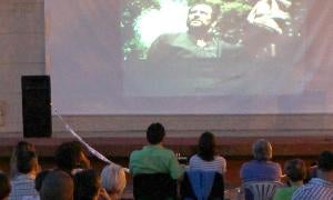 Un grupo de personas en el barrio de la Victoria disfruta viendo de la película También la lluvia de Iciar Bollaín. / Kike Gómez/