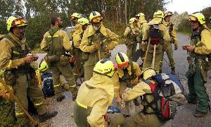 Miembros de una cuadrilla de León descansan durante la extinción de un incendio en Galicia. / S. S.-Efe/