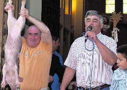 Gerardo Muñoz, que volvió a dirigir la subasta, junto a un vecino que pujó por un cochinillo. / Cruz Catalina/