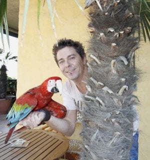 Javier posa con Paco, un loro que adiestra ahora. :: ISABEL SANZ/