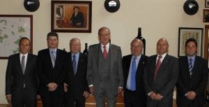 Don Juan Carlos posa con los hermanos Pérez Pascuas y sus hijos en la bodega de Pedrosa, delante del cuadro del abuelo Mauro. :: EL NORTE/