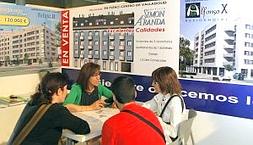 Tres clientes observan los planos de una de las viviendas en oferta en el puesto de la promotora Torcasa, en el VI Salón Inmobiliario Sivall. :: RAMÓN GÓMEZ/