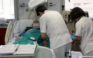 Dos enfermeras atienden a un anciano ingresado en el Hospital General de Segovia. :: ANTONIO DE TORRE/